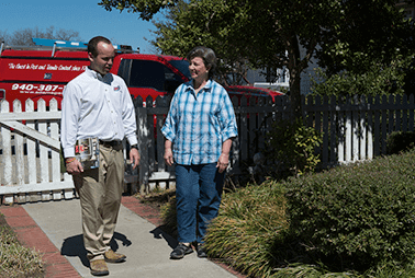 Woman in a garden with a pest control worker
